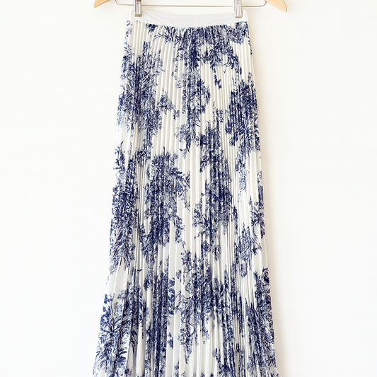 Blue and white patterned skirt on a hanger against a white background