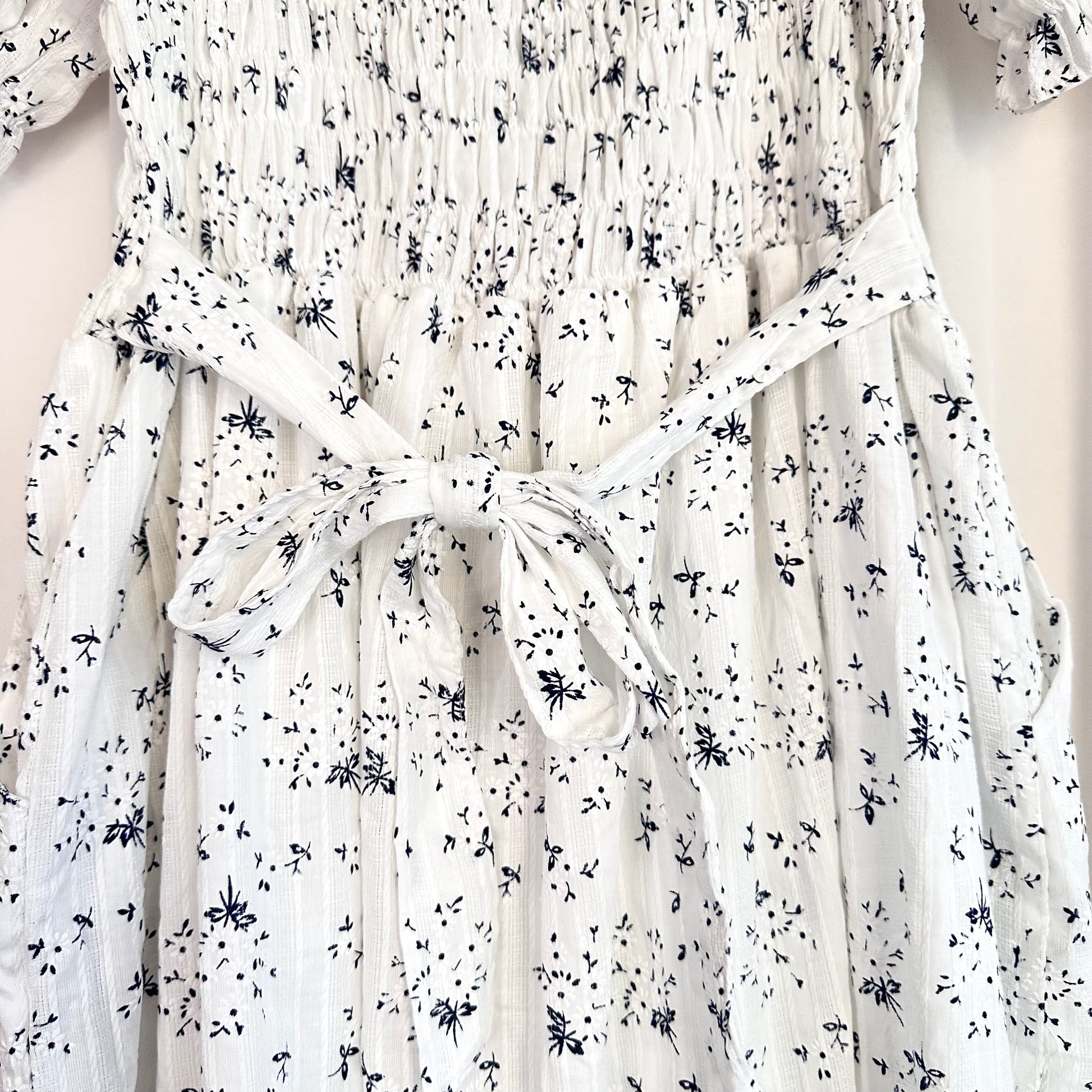 White dress with black floral pattern on a mannequin