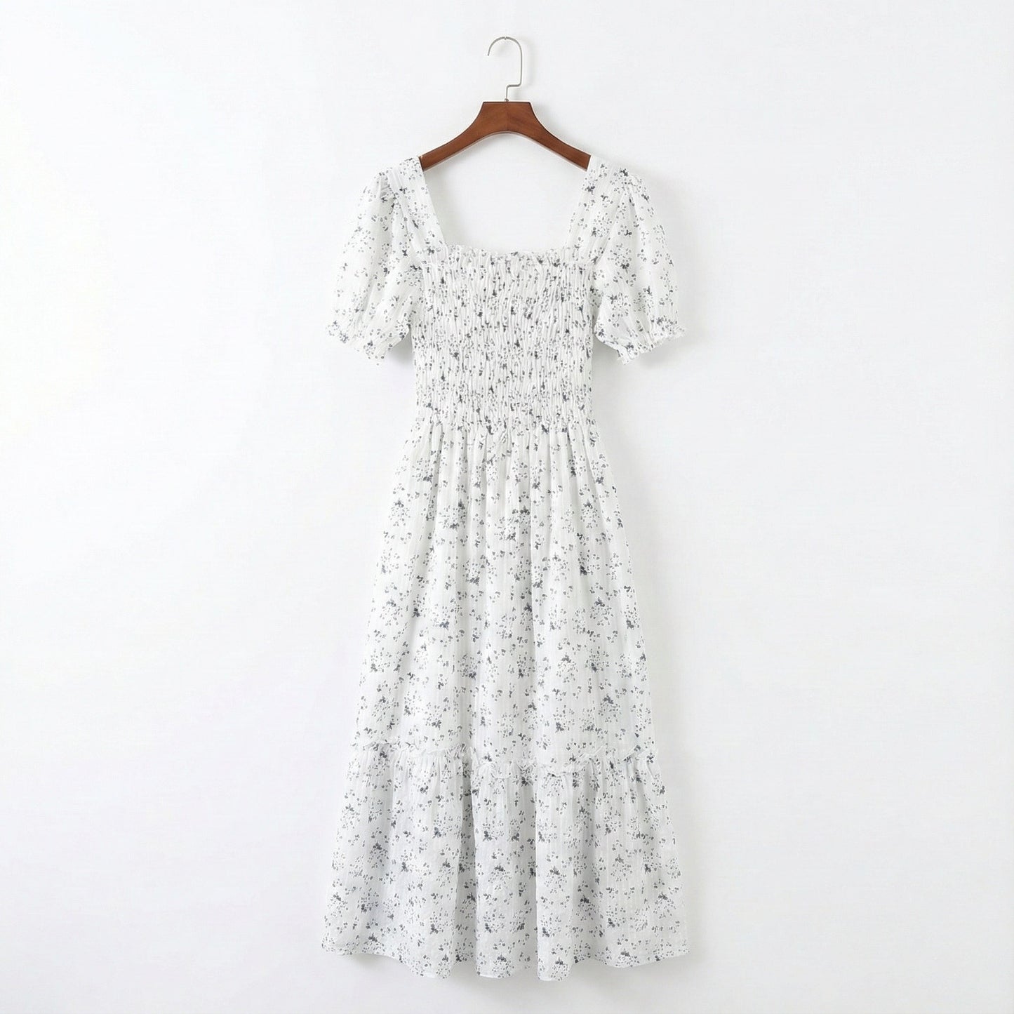 Floral dress on a hanger against a white background