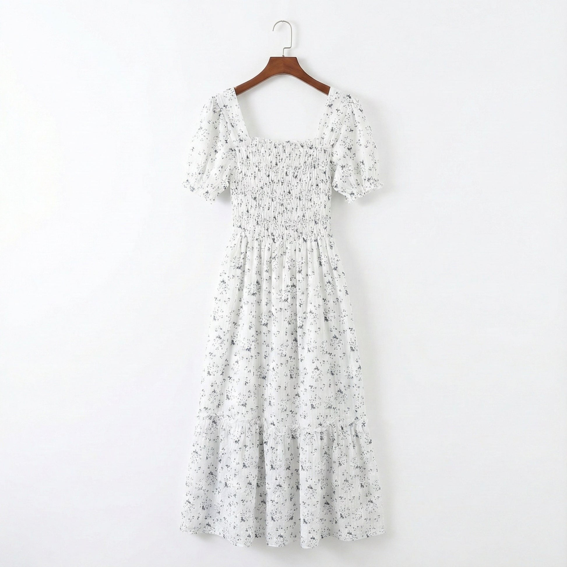 Floral dress on a hanger against a white background